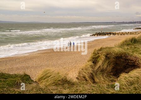 Hengistbury Head, Christchurch, Dorset, England, Vereinigtes Königreich Januar 2024, Wetter. Kühl und luftig an der Südküste. Wetterwarnungen wurden für das ganze Vereinigte Königreich ausgegeben, als sich der Sturm Isha nähert. Leute am Strand am rauen Meer. Quelle: Paul Biggins/Alamy Live News Stockfoto