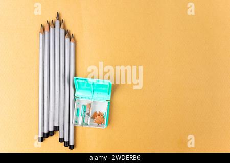 Mehrere Bleistifte und ein Anspitzer auf gelbem Hintergrund. Kopierbereich Stockfoto