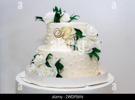 Zweistufige weiße Hochzeitstorte mit weißen Rosen Stockfoto