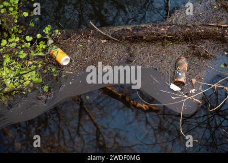 Müll auf dem Landweg, zerknitterte Dosen im Fluss Stockfoto