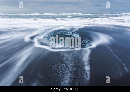Eisfelsen mit schwarzem Sandstrand am Jokulsarlon Beach, Diamond Beach, im Südosten Islands Stockfoto