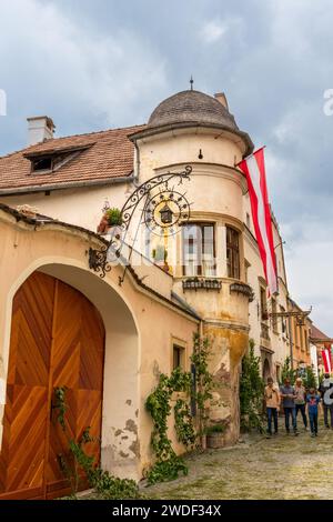 Dürnstein, Niederösterreich – AT – 8. Juni 2023 vertikales Bild von Touristen, die auf einer der malerischen Steinstraßen Dürnsteins zu Corpus C gehen Stockfoto