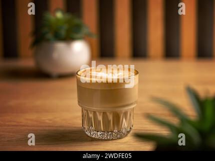 Heiße cremige Milch in Kaffee. Flacher weißer Kaffee in einer transparenten Glasschale Stockfoto