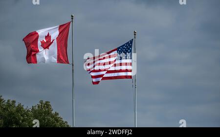 Amerikanische und kanadische Flaggen zusammen. Amerikanische und kanadische Flaggen fliegen nebeneinander an der Grenze zwischen den USA und Kanada im Peace Arch Blaine. Trave Stockfoto