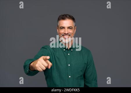 Glücklicher Geschäftsmann mittleren Alters, der auf Sie zeigt, isoliert auf grauem Hintergrund. Stockfoto