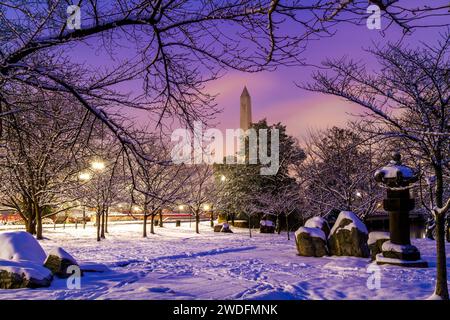 Eine schneebedeckte Szene im Tidal Basin in Washington, DC, mit der japanischen Laterne im Vordergrund und dem Washington Monument in der Ferne. Stockfoto