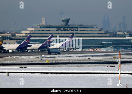 Cargomaschinen von FedEx und UPS stehen am Köln Bonn Airport - im Hintergrund das Hauptgebäude und der Kölner Dom. Nach starkem Schneefall wirkt sich das Wetter auch auf den Flugbetrieb am Flughafen Köln/Bonn aus. Der kontinuierliche Winterdienst mit Räumfahrzeugen machen die Taxiways und Lande- und Startbahnen wieder benutzbar. Themenbild, Symbolbild Köln, 20.01.2024 NRW Deutschland *** Frachtflugzeuge von FedEx und UPS parken am Flughafen Köln Bonn im Hintergrund Hauptgebäude und Kölner Dom nach starkem Schneefall wirkt sich das Wetter auch auf den Flugbetrieb bei Köln Bonn Air aus Stockfoto