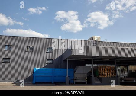 Laderampen eines Lagers. Wellblechlager Industriegebäude vor blauem, klarem Himmel Stockfoto