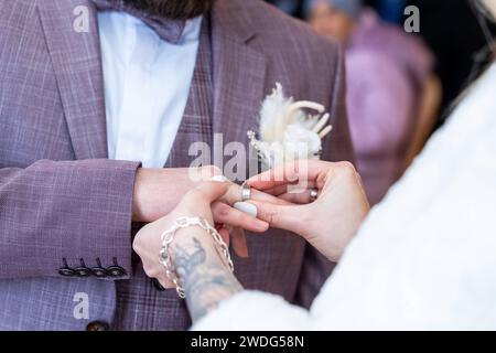 Augsburg, Bayern, Deutschland - 19. Januar 2024: Braut und Bräutigam haben sich bei ihrer Hochzeit die Eheringe an die Hände gelegt *** ein Brautpaar steckt sich gegenseitig die Eheringe an die Hände bei der Hochzeit Stockfoto