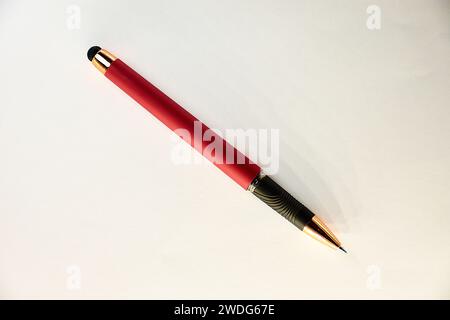 Ein Stift mit seiner Spitze in Rot, Schwarz und Gold auf weißem Hintergrund Stockfoto