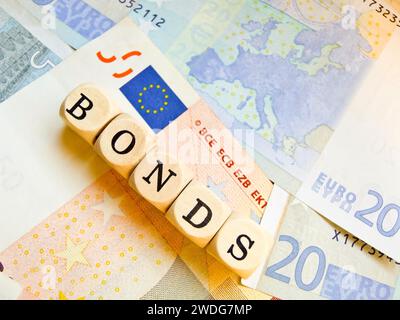 Holzwürfel mit der Aufschrift "BONDS" auf einem Hintergrund von Euro-Banknoten, Umriss des europäischen Kontinents, Europa auf einer der Banknoten, EU Stockfoto