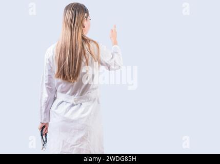 Rückansicht der Ärztin, die isoliert zeigt. Junge Ärztin von hinten mit dem Zeigefinger isoliert Stockfoto