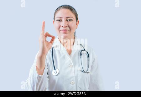 Schöne Ärztin mit Gesten Genehmigung isoliert. Lächelnde Ärztin, die isoliert zustimmt und empfiehlt Stockfoto
