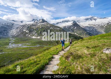 Zwei Bergsteiger auf Wanderweg in malerischer Berglandschaft, Berggipfel mit Schnee und Gletscher Schwarzensteinkees, Hornkees und Waxeggkees Stockfoto