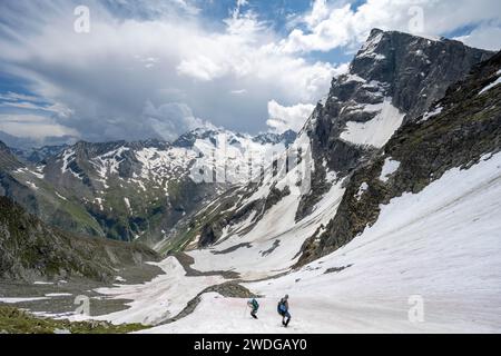 Bergsteiger wandern in einem Schneefeld, Noerdliche Mürchnerscharte, hinter dem Gipfel Greizer Spitze mit Schnee, Berliner Hoehenweg, Zillertaler Alpen Stockfoto