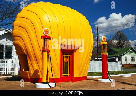 Eine alte gelbe Shell Tankstelle, gebaut, die dem muschelförmigen Logo des Unternehmens ähnelt, steht immer noch als Attraktion am Straßenrand Stockfoto