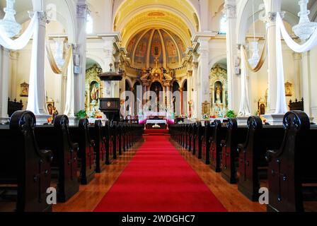 Ein Gang führt an den Bänken vorbei und zum Altar der portugiesischen Nationalkirche in San Jose, Kalifornien Stockfoto