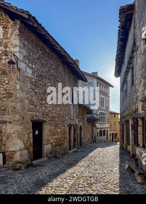 Wunderschöner Blick auf die malerische enge Gasse mit historischen Steinhäusern und Kopfsteinpflasterstraße in der Altstadt von Perouge in Frankreich. Stockfoto