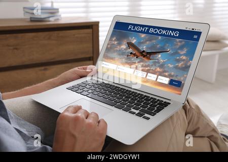 Mann mit Laptop, um zu Hause Flug zu buchen, Nahaufnahme Stockfoto