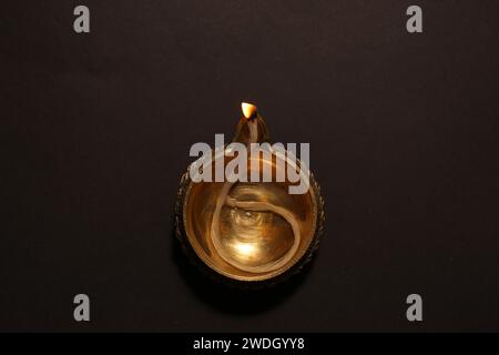 Beleuchtete Diya auf dunklem Hintergrund, Draufsicht. Diwali-Lampe Stockfoto