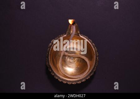 Beleuchtete Diya auf dunklem Hintergrund, Draufsicht. Diwali-Lampe Stockfoto