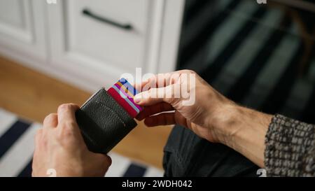 Nahaufnahme von Mann Hand öffnet Kartenmappe voller Kreditkarten, nimmt eine heraus Stockfoto