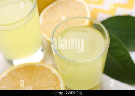 Leckerer Limoncello-Likör und Zitronen auf dem Tisch, Nahaufnahme Stockfoto