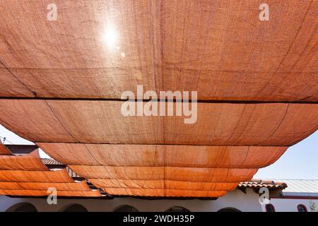 Netzschatten schützen die Gebäudeterrasse vor der heißen Sonne Stockfoto