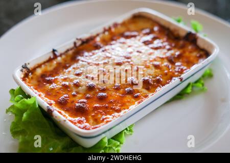 Lasagne in einer Schüssel serviert, mit Gemüse auf Teller Stockfoto