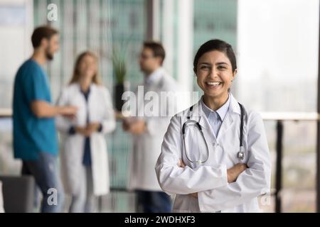 Fröhlich schöne indische Ärztin Frau in Uniform genießt medizinische Beschäftigung Stockfoto