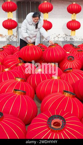 Suqian, China. Januar 2024. Ein Arbeiter trocknet rote Laternen in einer Kunsthandwerksfabrik in Suqian, Provinz Jiangsu, China, am 21. Januar 2024. (Foto: Costfoto/NurPhoto) Credit: NurPhoto SRL/Alamy Live News Stockfoto