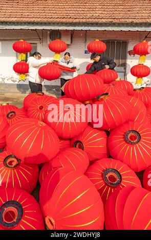 Suqian, China. Januar 2024. Arbeiter trocknen rote Laternen in einer Kunsthandwerksfabrik in Suqian, Provinz Jiangsu, China, am 21. Januar 2024. (Foto: Costfoto/NurPhoto) Credit: NurPhoto SRL/Alamy Live News Stockfoto