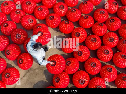 Suqian, China. Januar 2024. Ein Arbeiter trocknet rote Laternen in einer Kunsthandwerksfabrik in Suqian, Provinz Jiangsu, China, am 21. Januar 2024. (Foto: Costfoto/NurPhoto) Credit: NurPhoto SRL/Alamy Live News Stockfoto