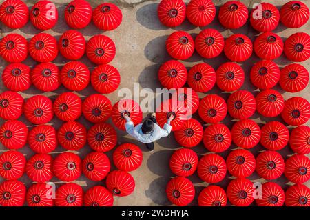 Suqian, China. Januar 2024. Ein Arbeiter trocknet rote Laternen in einer Kunsthandwerksfabrik in Suqian, Provinz Jiangsu, China, am 21. Januar 2024. (Foto: Costfoto/NurPhoto) Credit: NurPhoto SRL/Alamy Live News Stockfoto