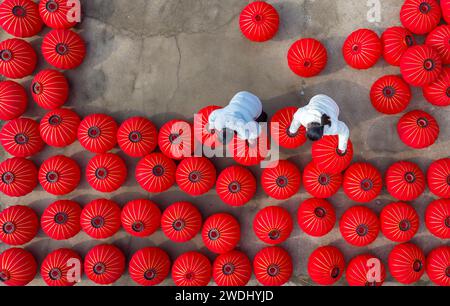 Suqian, China. Januar 2024. Arbeiter trocknen rote Laternen in einer Kunsthandwerksfabrik in Suqian, Provinz Jiangsu, China, am 21. Januar 2024. (Foto: Costfoto/NurPhoto) Credit: NurPhoto SRL/Alamy Live News Stockfoto