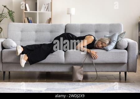 Blick über die ganze Länge, müde, reife Frau hat auf dem Sofa geschlafen Stockfoto