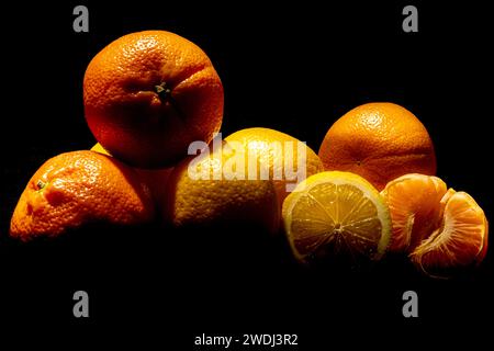 Zitronen und Mandarinen auf schwarzem Hintergrund. Gesunde Früchte. Entgiftung. Zitrusfrüchte in der Küche. Körperreinigung. Stockfoto