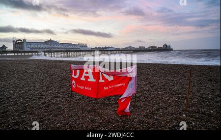 Brighton UK 21. Januar 2024 - Ein Gefahrenschild am Strand von Brighton wird heute Morgen von starken Winden zerrissen, da der Sturm Isha später heute über Großbritannien fegen wird, wobei bernsteinfarbene Wetterwarnungen ausgegeben werden, die Windprognosen in einigen Teilen 8 km/h erreichen: Credit Simon Dack / Alamy Live News Stockfoto