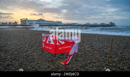 Brighton UK 21. Januar 2024 - Ein Gefahrenschild am Strand von Brighton wird heute Morgen von starken Winden zerrissen, da der Sturm Isha später heute über Großbritannien fegen wird, wobei bernsteinfarbene Wetterwarnungen ausgegeben werden, die Windprognosen in einigen Teilen 8 km/h erreichen: Credit Simon Dack / Alamy Live News Stockfoto