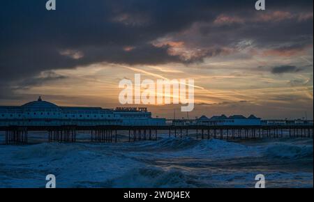 Brighton UK 21. Januar 2024 - die Wellen brechen heute Morgen am Brighton Palace Pier bei Sonnenaufgang ein, als der Sturm Isha heute über Großbritannien fegt und bernsteinfarbene Wetterwarnungen ausgegeben werden, wenn die Windvorhersage in einigen Teilen 8 km/h erreichen wird: Credit Simon Dack / Alamy Live News Stockfoto