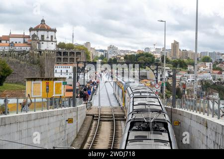 Porto, Portugal - 17. September 2023. U-Bahn und Fußgänger auf der Ponte D. Luis I. Douro River und Terrakota Dächer, UNESCO-Weltkulturerbe Stockfoto