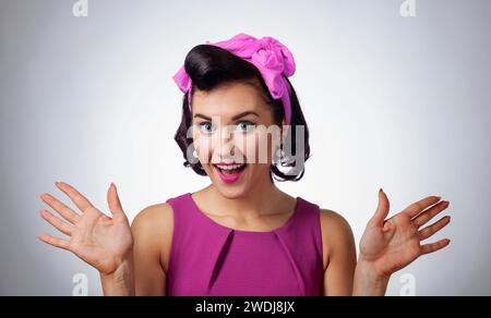 Schöne brünette Frau in lila Kleid mit perfektem Haar und Make-up. Ausdrucksstarker Gesichtsausdruck. Stockfoto