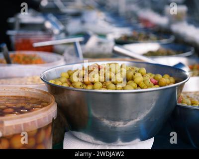 San Miguel de Salinas – Eine Schüssel mit frisch marinierten Oliven auf dem beliebten Straßenmarkt in San Miguel de Salinas, Alicante Spanien. Das wöchentliche Marktattr Stockfoto