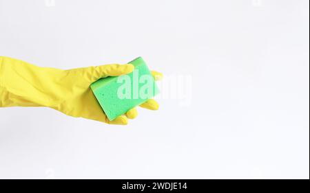 Die Hand einer Frau in einem gelben Latexhandschuh hält einen Spülschwamm. Reinigung der Räumlichkeiten. Professionelle Reinigung. Haushaltshandschuhe, gelb. Reinigungsauftrag Stockfoto