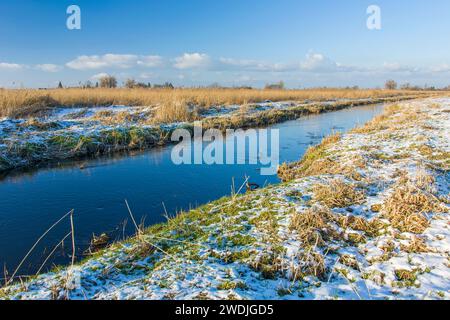 Ein kleiner Fluss in Ostpolen mit schneebedecktem Ufer Stockfoto