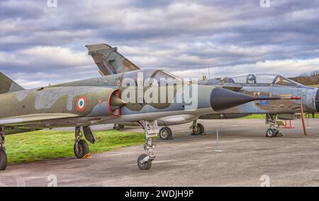 Ein französisches Mirage-Kampfflugzeug in einem Luftmuseum. Ein Tornado GR1 befindet sich hinter dem Mirage und ein Himmel mit Wolken darüber. Stockfoto