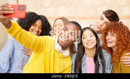 Afrikanischer Mann macht ein Selfie mit multiethnischen Freunden draußen Stockfoto