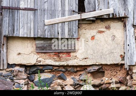 Alte Bauernhausmauer mit Schrankdach und Steinmauer Stockfoto