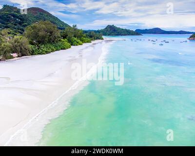 Blick aus der Vogelperspektive auf weißen Sand und türkisfarbenes Wasser am Strand von Anse Volbert auf der Insel Praslin, Seychellen Stockfoto