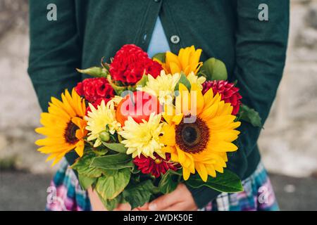 Wunderschöner Blumenstrauß mit hellen und bunten Blumen, die an Kinderhänden gehalten werden Stockfoto